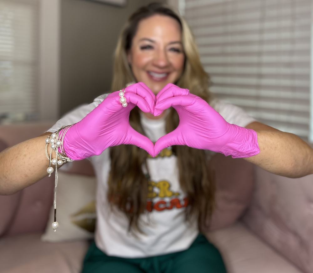 Priscilla from Opal Aesthetics & Wellness making a heart shape with gloved hands