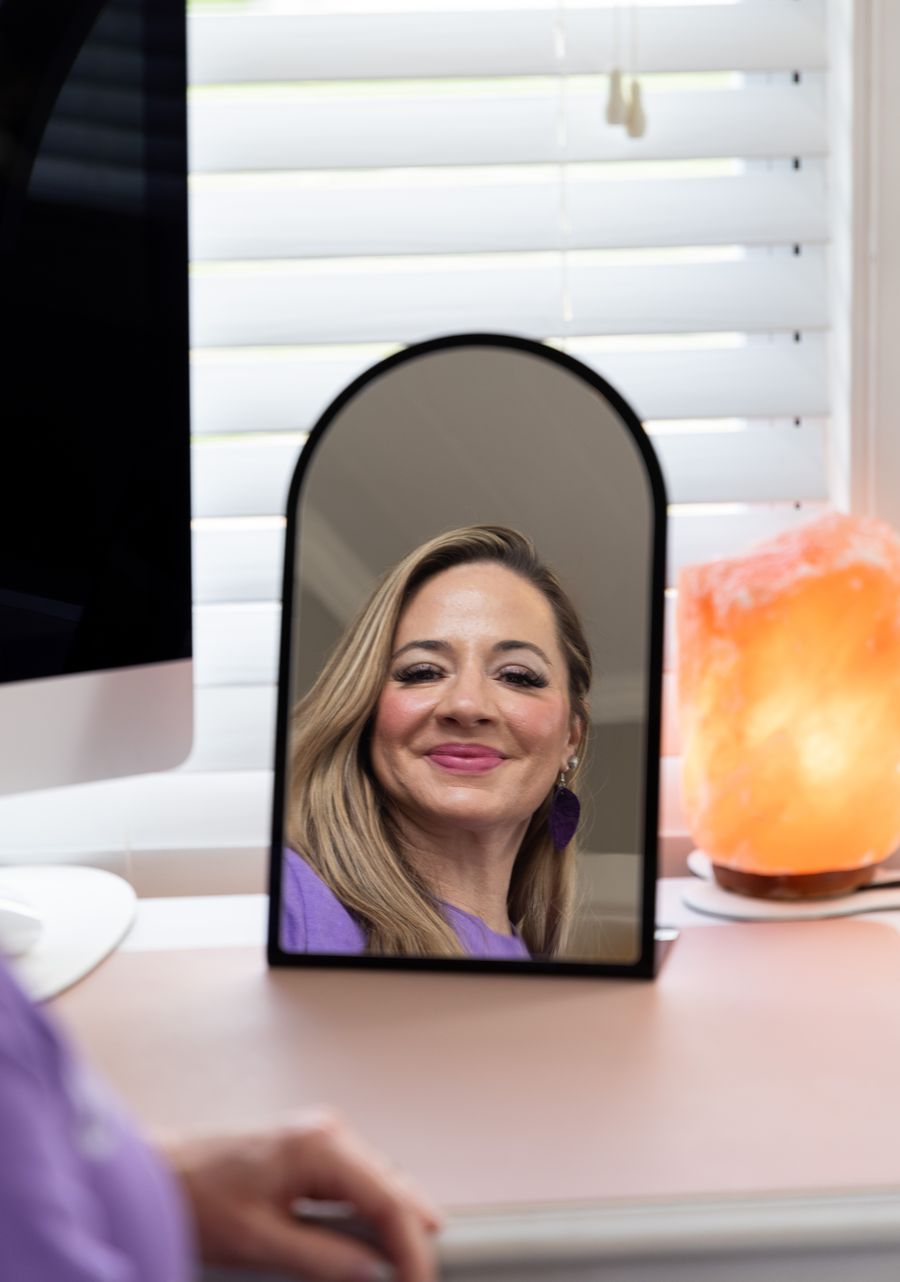 Priscilla, founder of Opal Aesthetics & Wellness, at her desk in Dripping Springs